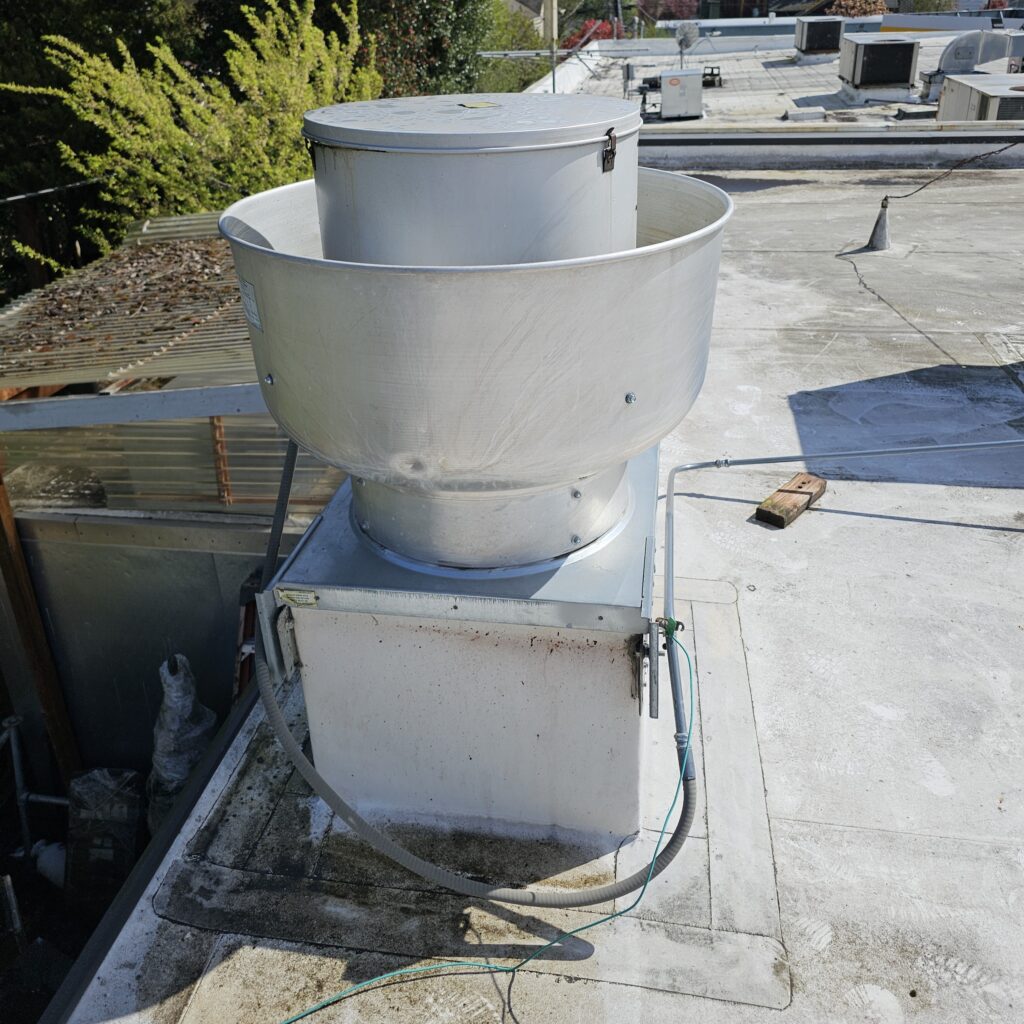 Ventilation equipment inspected as part of commercial HVAC repairs on a flat roof.