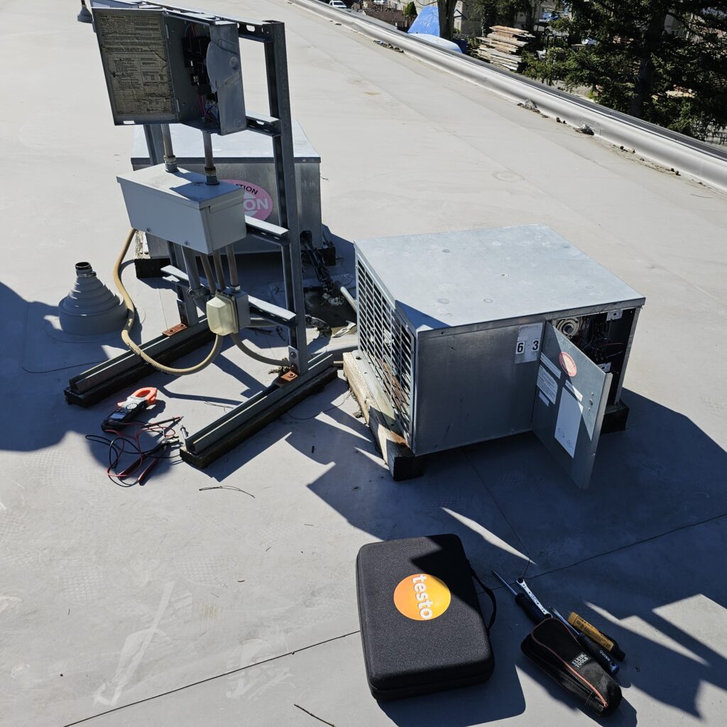 20250417_161230 Rooftop commercial refrigeration unit opened for maintenance with tools and testing equipment nearby, illustrating professional commercial freezer repair work.