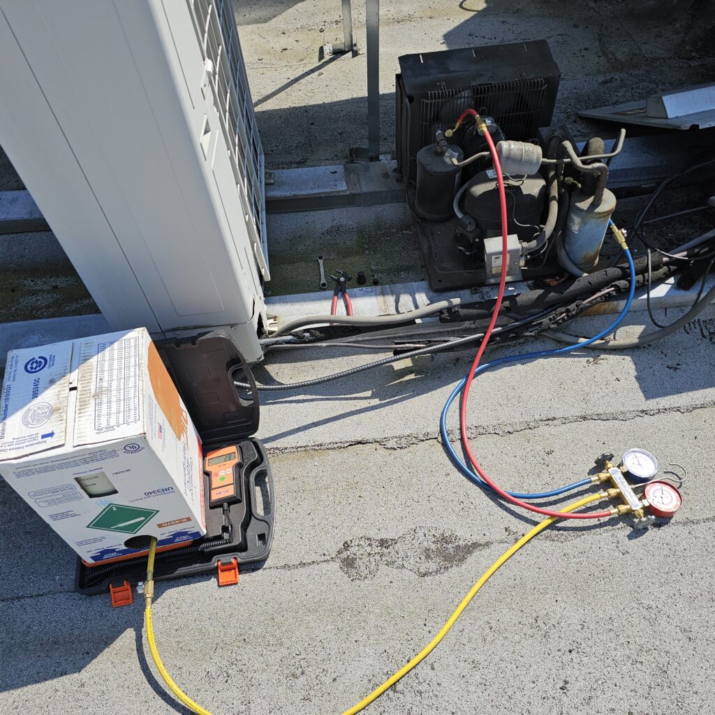 commercial refrigeration repairs 2 Commercial refrigeration unit being serviced outdoors with manifold gauges, hoses, and tools connected to the system, representing professional commercial refrigeration repair service.