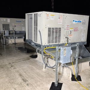 Rooftop package unit undergoing commercial HVAC repair at a commercial facility.