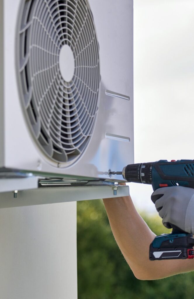 Working process A/C Dr. Naz technician performs air conditioning repairs in seattle with a blue drill