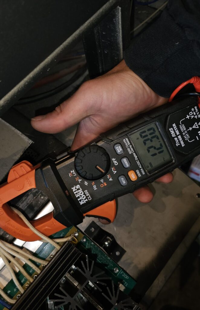 Techinchian is testing commercial refrigerator with a clamp meter in one of seattle's restaurant