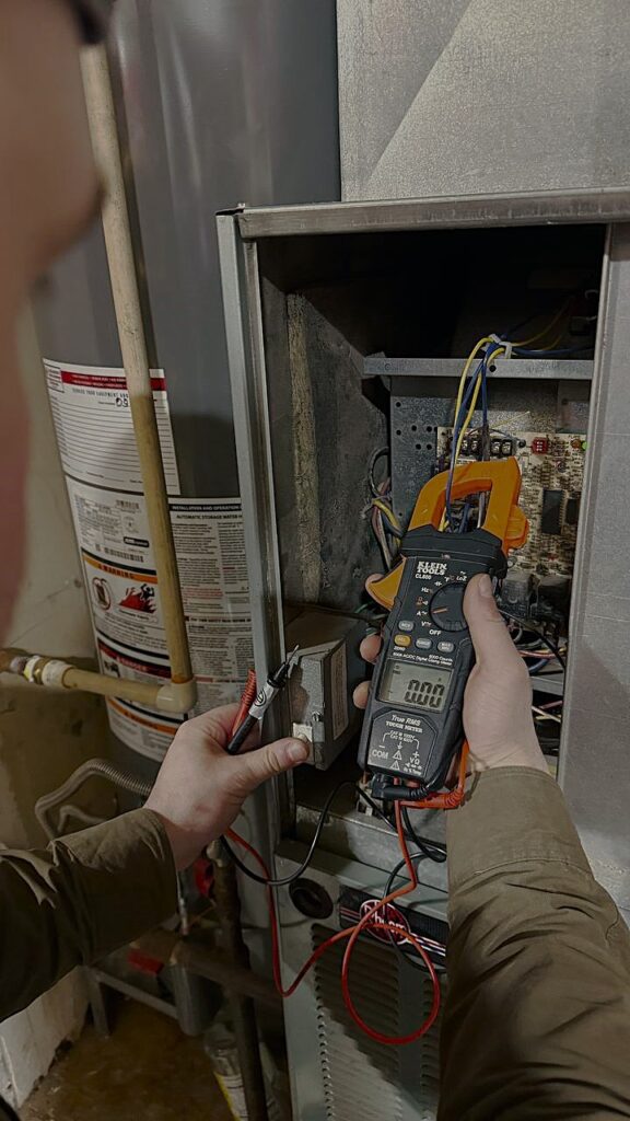 Licensed HVAC technician using a manometer to calibrate gas pressure for a high-efficiency furnace in Snohomish County.