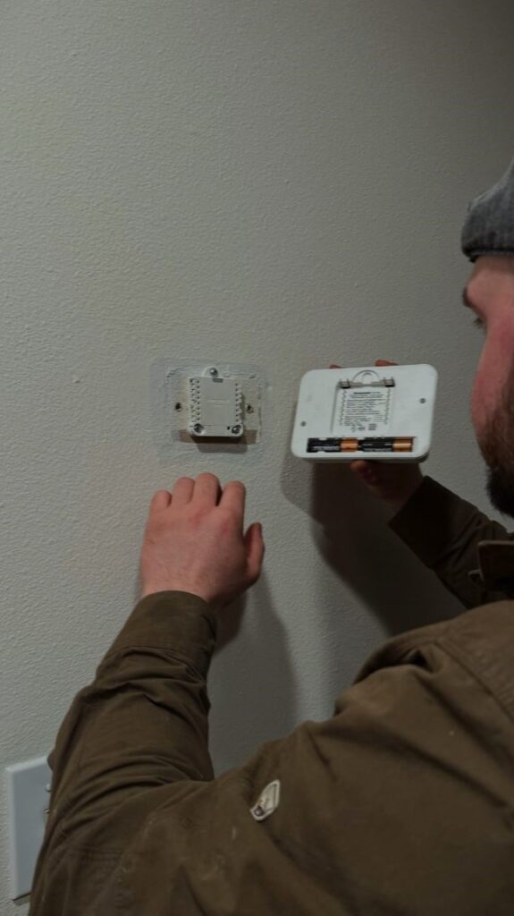 Close-up of HVAC technician troubleshooting low-voltage wiring for a home thermostat in Everett.