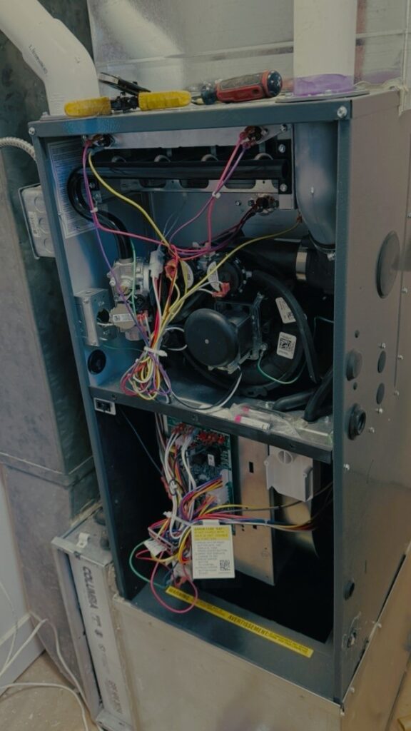 HVAC professional cleaning a furnace burner assembly for better efficiency.