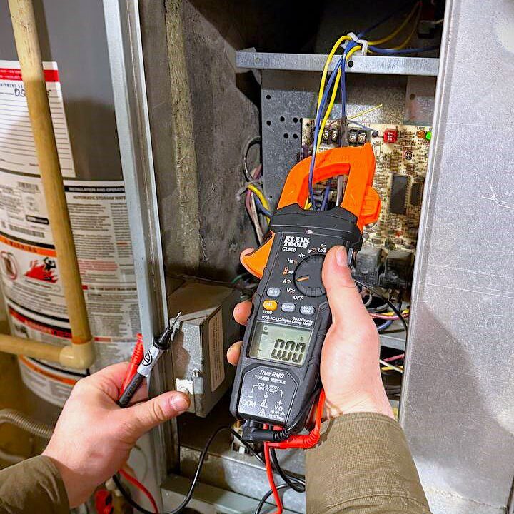 How We Restored Heat for a Marysville Home a gas furnace repair case study. Naz is checking the furnace with digital multimeter