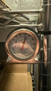 The Nor-Lake walk-in unit showing an internal temperature reading well above the safe holding range.