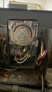 Close-up of the faulty defrost clock. Testing confirmed that while the timer motor was running, the mechanical switch to trigger the heaters had failed.