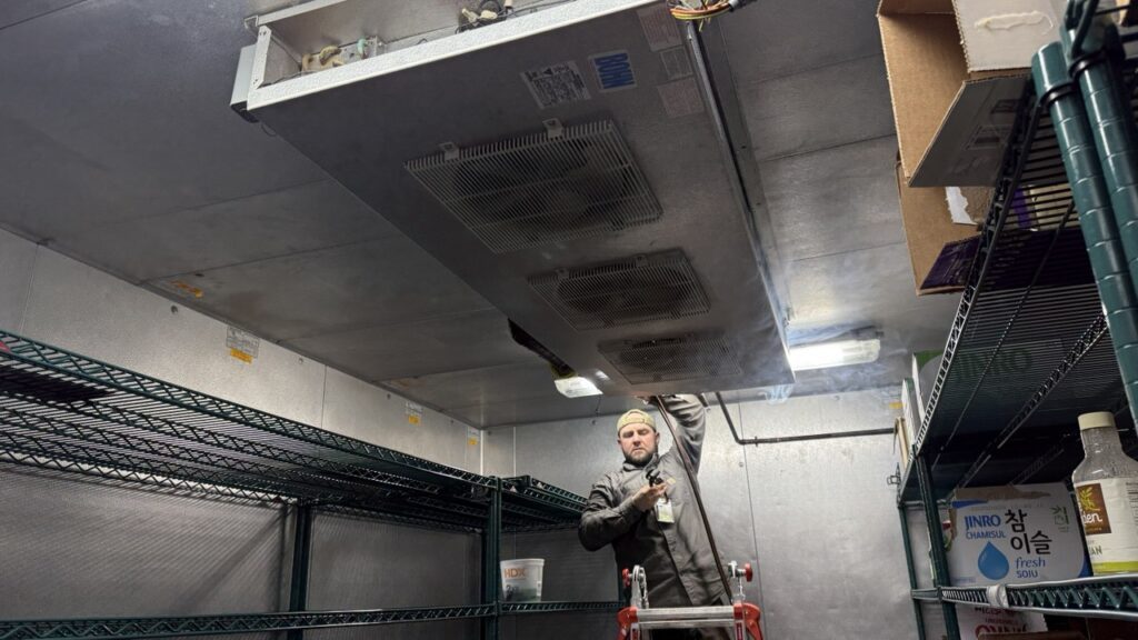 Evaporator Coil Repair & Maintenance. technician is working on walk in cooler repairs.