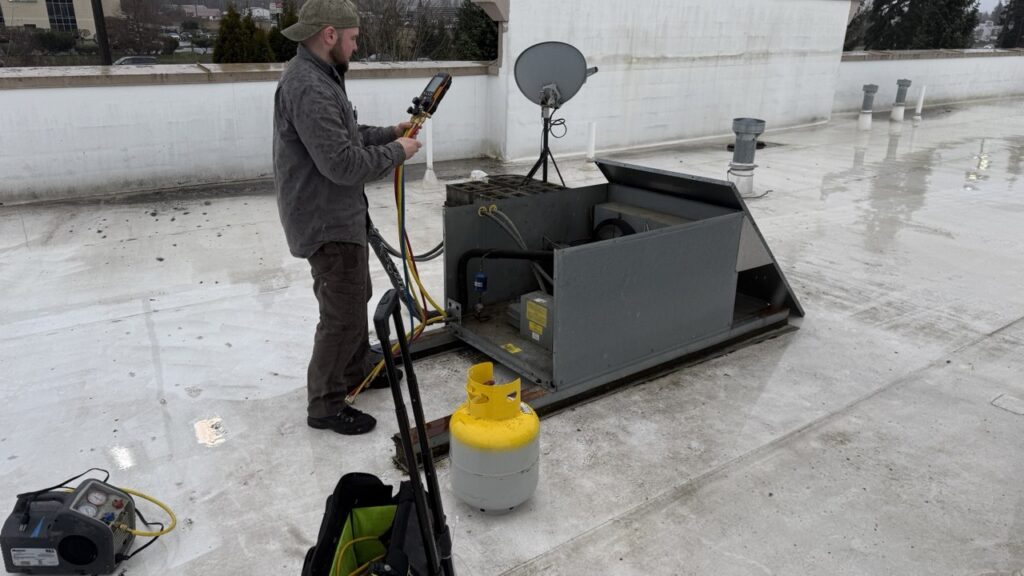 Technician is working on condenser coil repair and testing it with industry grade tool 