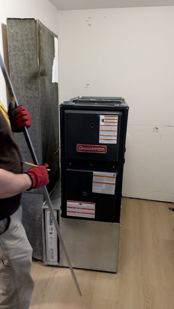 A/C Dr. Naz technician performing a multi-point inspection for a furnace repair in a Seattle home.