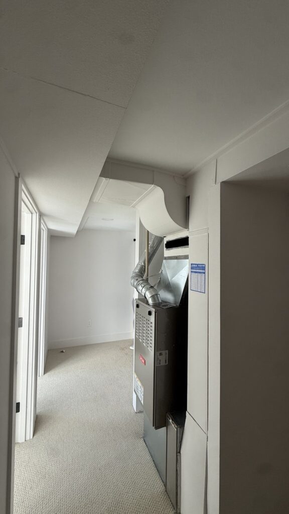 Removing the service panel of a home heating system to inspect the burner assembly and ignitor.