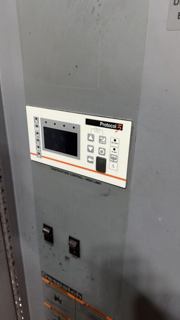 A kitchen manager reviewing equipment logs to minimize restaurant kitchen appliance downtime through proactive convection oven maintenance.