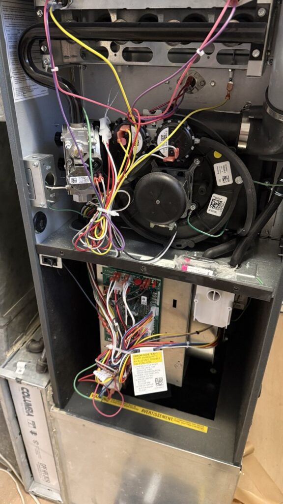 Close-up of a dusty furnace blower motor being cleaned and repaired by A/C Dr. Naz.