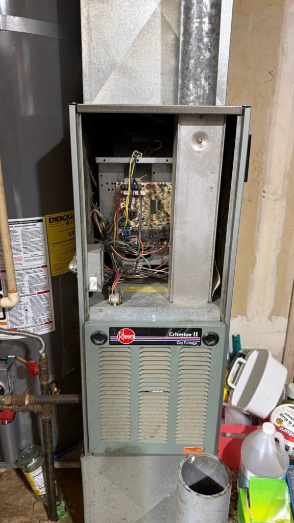 Open furnace service panel showing components during repair