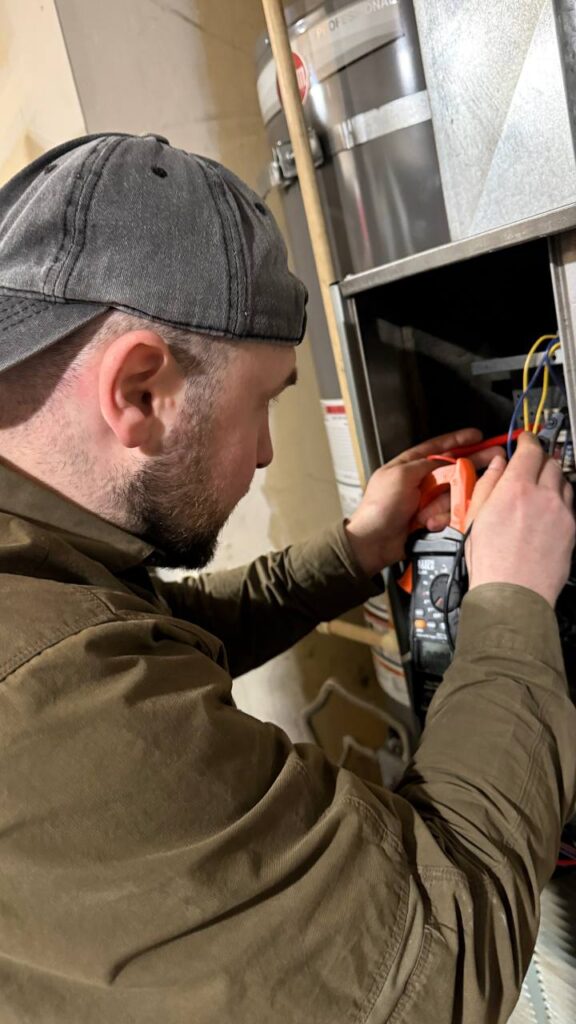 A/C Dr. Naz HVAC technician diagnosing residential furnace during heating service in Marysville, WA