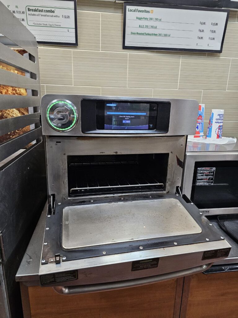 Close-up of worn door seals and hinges on a commercial turbo oven before replacement service.