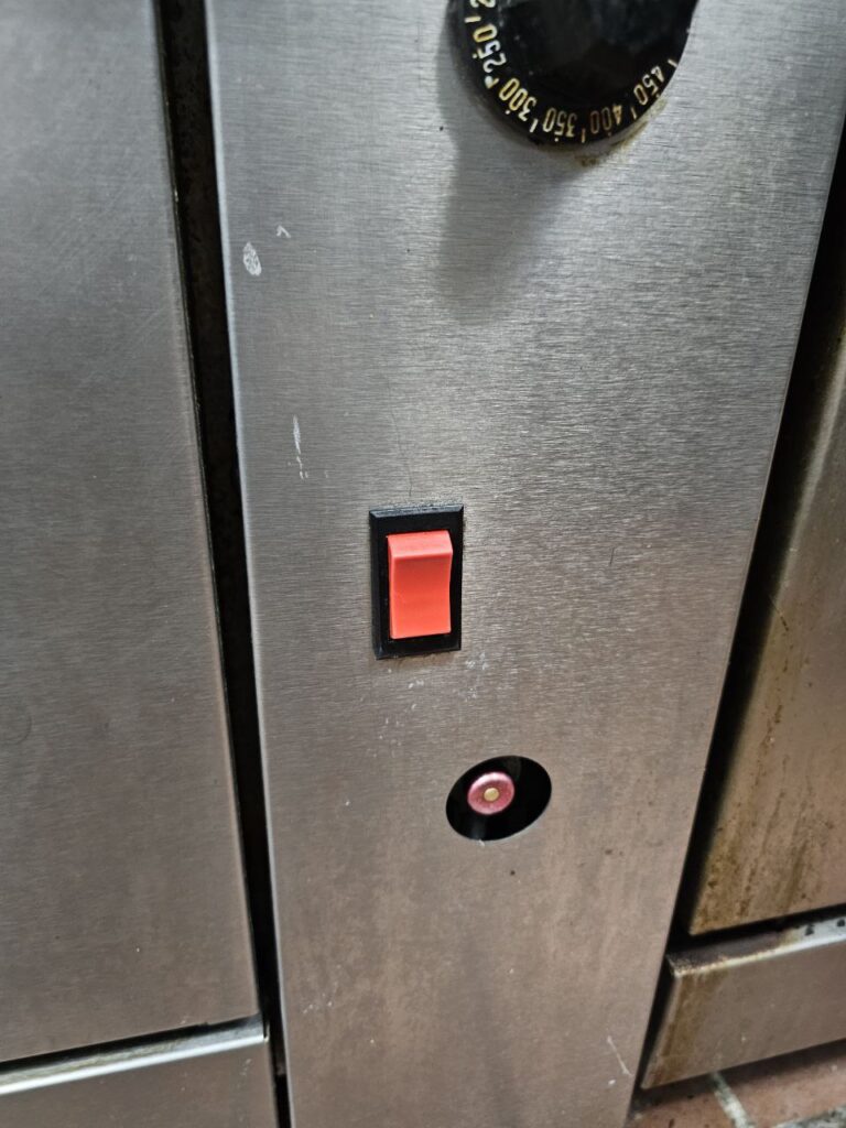 Stainless steel commercial gas range top with flat-top griddle attachment in a professional Seattle kitchen before receiving a comprehensive safety and gas pressure check.