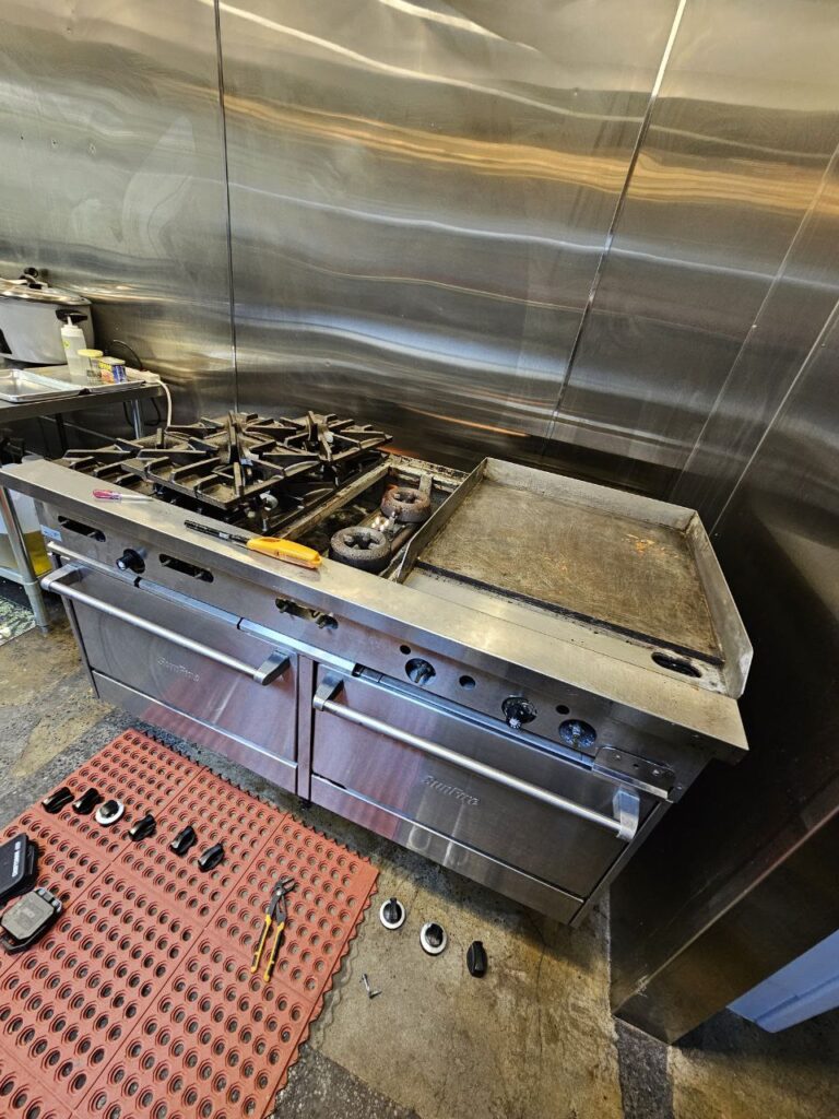 Non-functional Southbend heavy-duty restaurant range in Seattle showing a failed pilot light and thermocouple assembly before same-day repair service.