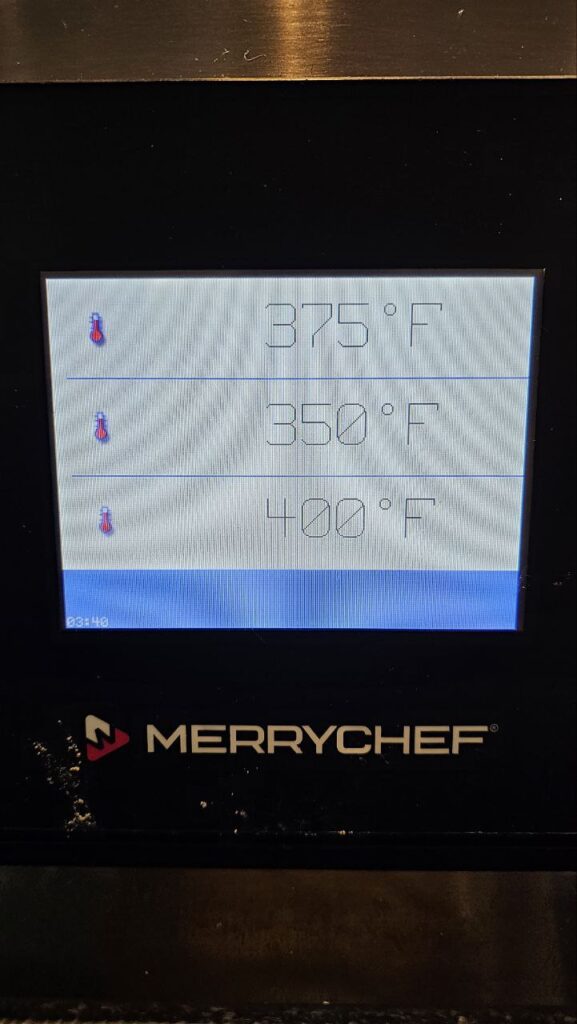 Close-up of a Merrychef eikon high-speed oven digital screen displaying a service required error code in a Seattle café.