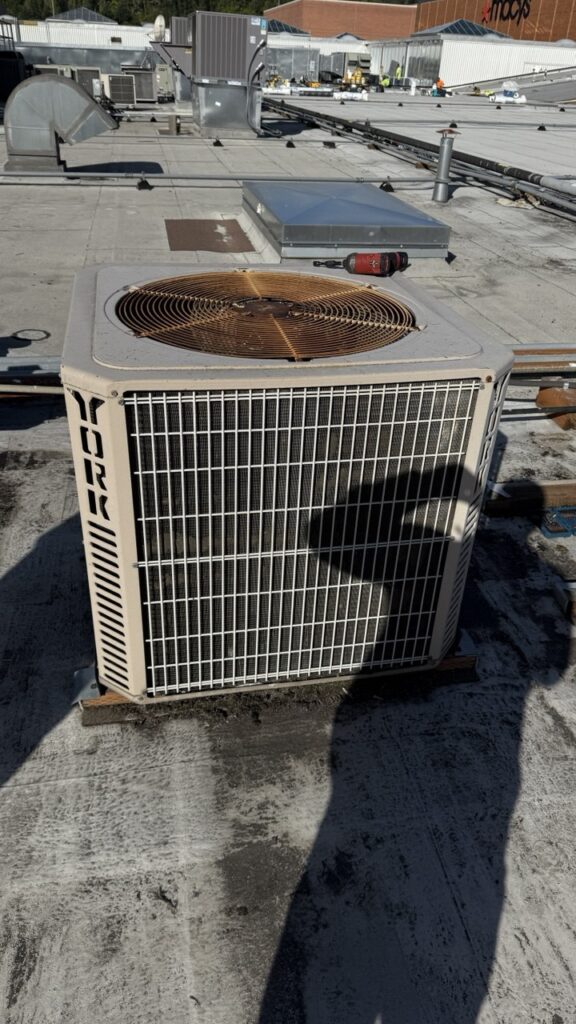 York commercial HVAC rooftop unit repair by A/C Dr. Naz in Seattle, WA, featuring a flat roof site with a red power drill ready for service.
