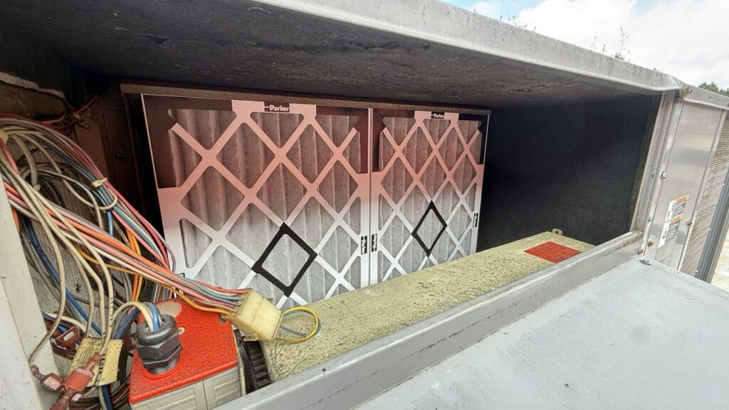 A commercial HVAC coil showing the significant difference between a dirty surface and a professionally cleaned section during maintenance.