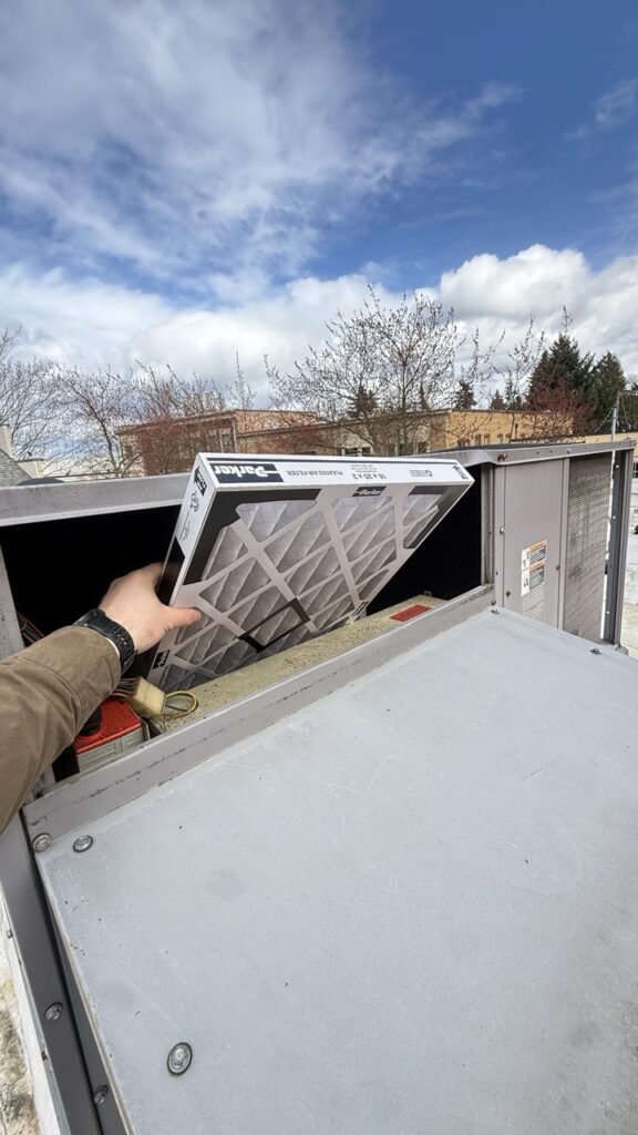 Close-up of a heavily clogged commercial HVAC condenser coil requiring professional cleaning to improve energy efficiency.