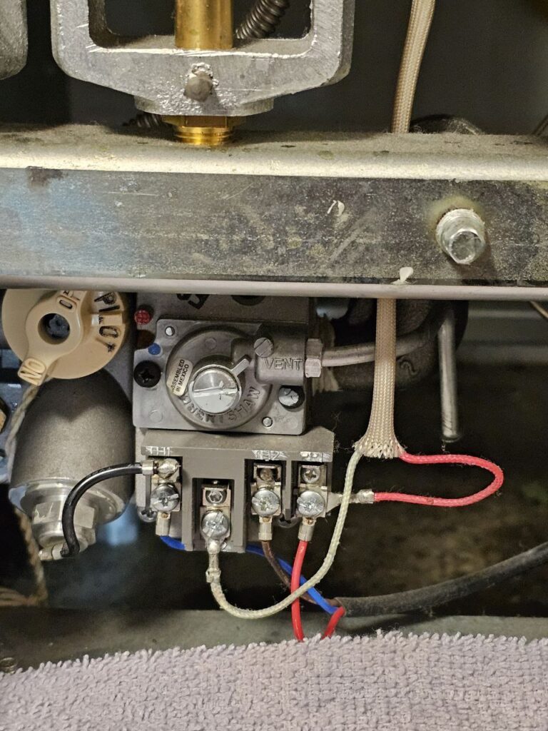 Interior shot of a commercial fryer's control area, showing the temperature adjustment dial (300°F to 400°F) and the associated electrical safety switches and wiring harnesses.