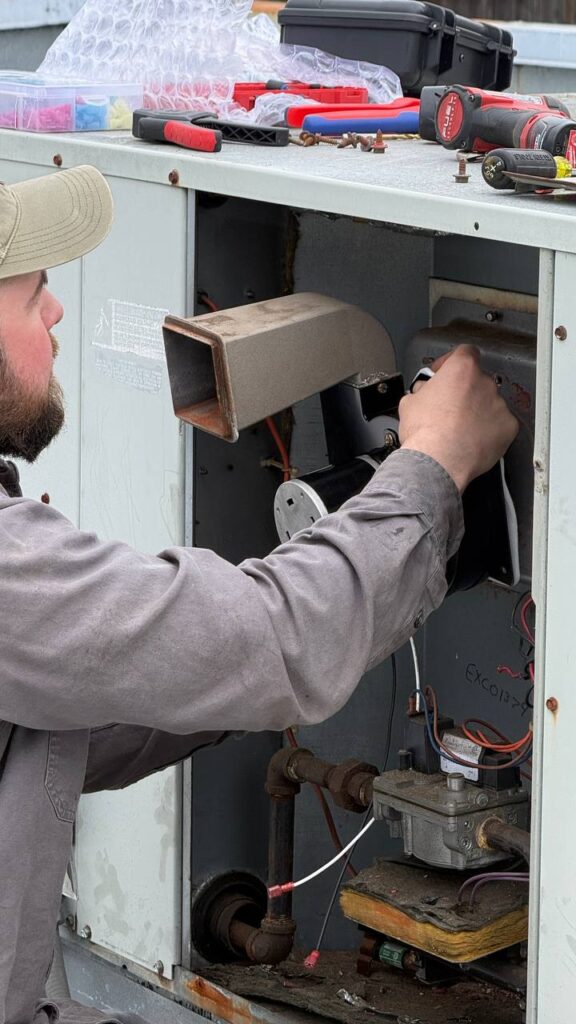 Commercial HVAC technician diagnosing rooftop unit electrical components in Seattle WA