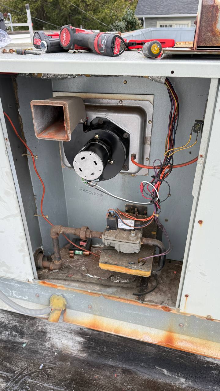 Opened rooftop unit with the inducer and heat section exposed