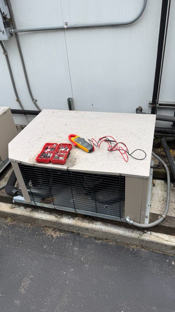 Clamp meter and tools at a commercial condenser during diagnostics