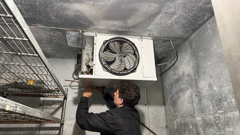 A/C Dr. Naz technician servicing a commercial walk-in cooler in Greater Seattle.