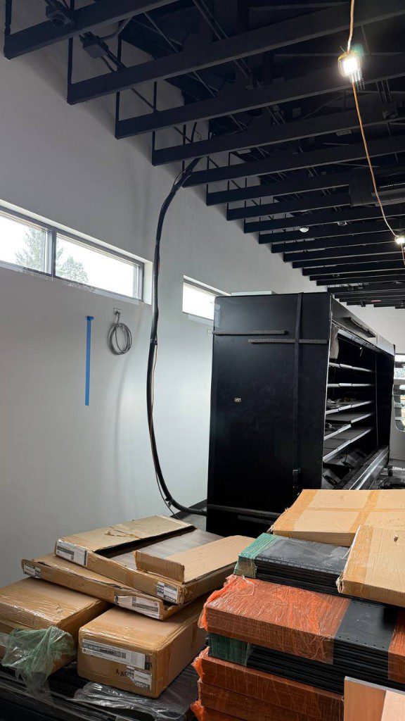 Field photo of multi-deck commercial display cooler installation in progress — serves Lake Forest Park, WA commercial refrigeration repair
