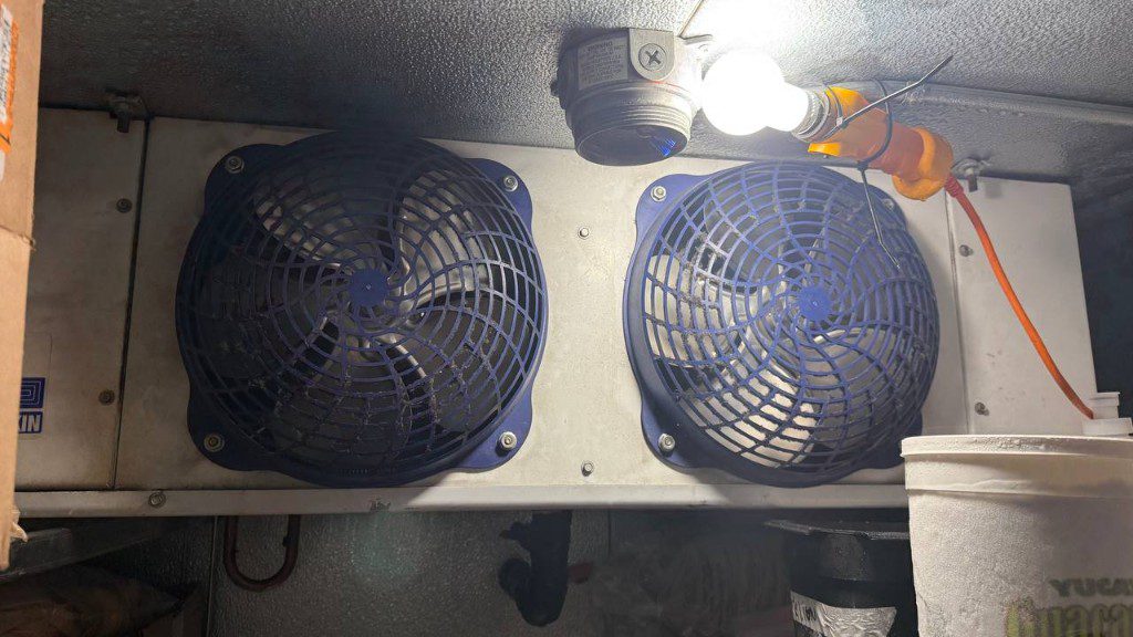 Field photo of walk-in cooler evaporator with two fans and temporary lighting — serves Granite Falls, WA commercial refrigeration repair
